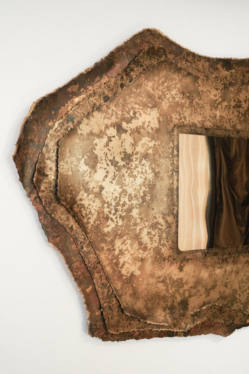 Miroir Chloris en laiton aux patines végétales de Yannick Szekany où le temps et le vivant se lisent dans la texture du métal. Cette pièce est inspirée des feuilles qui jongent le sol en période automnale. Les plantes qui ont servies à son oxydation ont toutes été récoltées dans la forêt de fontainebleau.