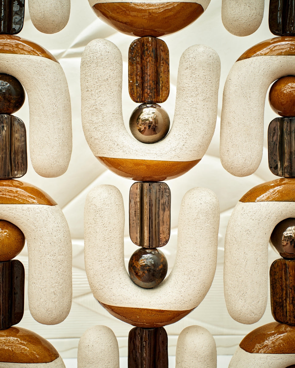 Ce paravent en céramique est né d’une envie de créer une séparation sculpturale qui soit à la fois fonctionnelle et expressive. Modulable, graphique, il structure l’espace tout en laissant passer la lumière.

Chaque élément a été pensé comme une forme simple et forte, presque humaine, qui évoque les totems ou des silhouettes stylisées. En les assemblant, une rythmique se crée, à la fois stable et vibrante.