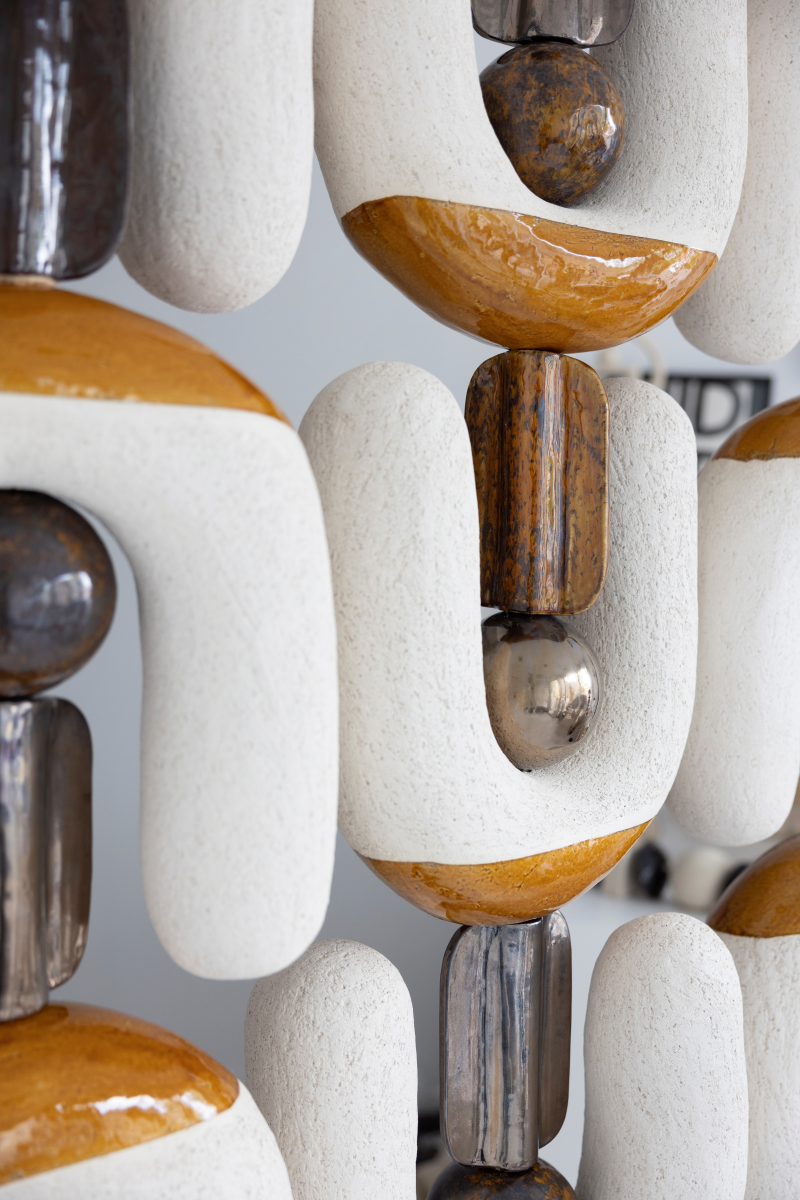 Ce paravent en céramique est né d’une envie de créer une séparation sculpturale qui soit à la fois fonctionnelle et expressive. Modulable, graphique, il structure l’espace tout en laissant passer la lumière.

Chaque élément a été pensé comme une forme simple et forte, presque humaine, qui évoque les totems ou des silhouettes stylisées. En les assemblant, une rythmique se crée, à la fois stable et vibrante.