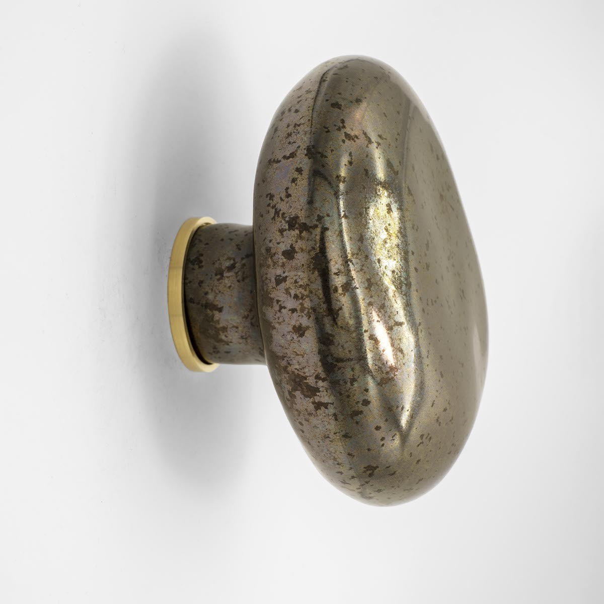 La patère Agate tire son nom de la pierre précieuse éponyme. Les Grecs et les Égyptiens l'utilisaient déjà dans la confection d'objets sacrés. Chaque patère possède sa propre personnalité, accentuée par les émaux cristallisés ou colorés qui s'harmonisent avec sa forme douce et organique, reflétant la diversité des teintes présentes dans les pierres d'Agate.

Son design intemporel et organique évoque la beauté et la simplicité des galets, tandis que sa délicate base est ornée d'une bague en laiton brossé.