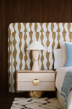 Paire de tables de chevet FAENA, imaginée par Caroline Andreoni pour la master bedroom d'une villa privée à Miami. Le caisson en chêne massif s'habille d'un placage en bois graphique aux tons ivoire et sable, posé sur un socle cylindrique en laiton poli.

Les photos affichées correspondent à la version la plus grande des chevets.