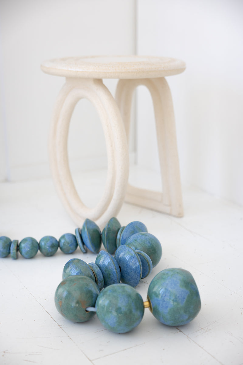 Bijou de sol en céramique chamottée et laiton, émaillé d'un bleu envoutant, façonné par Jehanne et Pascale de l'Atelier HD en collaboration avec Caroline Andréoni pour l'aménagement d'une master bedroom à Miami. Cette pièce a été spécialement repensée afin d'arborer un émail évoquant les nuances de la mer et dialoguant avec la vue spectaculaire qu'offre cette sublime villa.

La Lora diffuse une lumière chaude et directionnelle, soulignant la matière et créant une atmosphère à la fois intime et sculpturale.