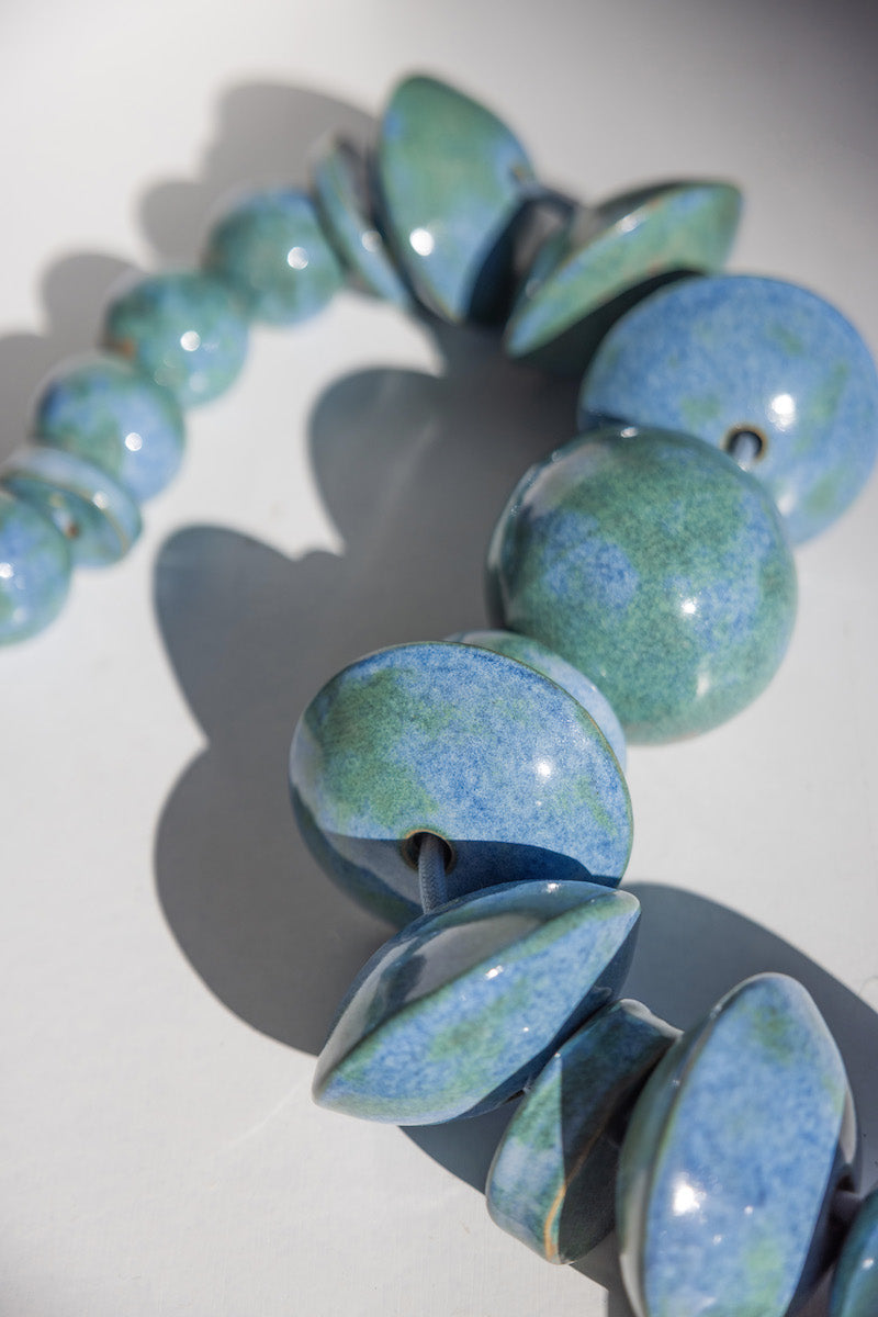Bijou de sol en céramique chamottée et laiton, émaillé d'un bleu envoutant, façonné par Jehanne et Pascale de l'Atelier HD en collaboration avec Caroline Andréoni pour l'aménagement d'une master bedroom à Miami. Cette pièce a été spécialement repensée afin d'arborer un émail évoquant les nuances de la mer et dialoguant avec la vue spectaculaire qu'offre cette sublime villa.

La Lora diffuse une lumière chaude et directionnelle, soulignant la matière et créant une atmosphère à la fois intime et sculpturale.