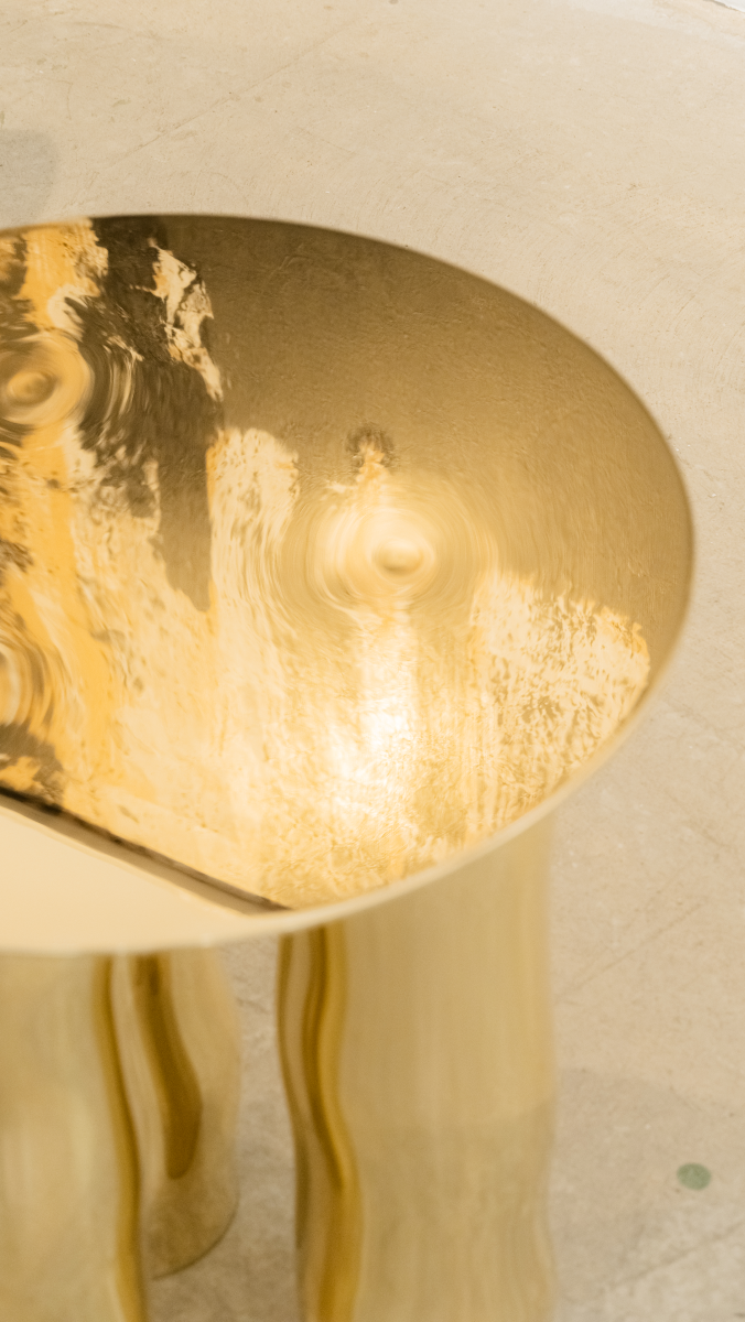 Mimo est une table d’appoint en laiton poli miroir, non verni. Sa structure repose sur une intention formelle simple : trois pieds et un plateau. Ses pieds, formés de manière organique, contrastent avec la ligne fine et délicate de son plateau.

La surface polie capte la lumière et reflète l’environnement, révélant l’élégance contenue dans la simplicité. Le laiton, travaillé à la main, invite à une expérience sensorielle où la matière et l’espace entrent en conversation.