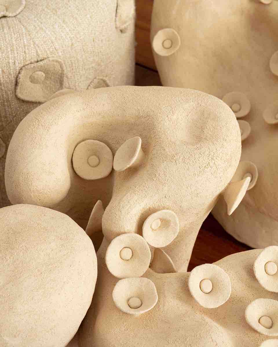 Table basse conçue et fabriquée par la céramiste Marguerite Porche. Deux larges pieds en grès blanc aux courbes sinueuses évoquant la roche sculptée par les éléments et parcourue de petites fleurs cherchant le soleil, portent un large plateau en verre d’un cm d’épaisseur. 