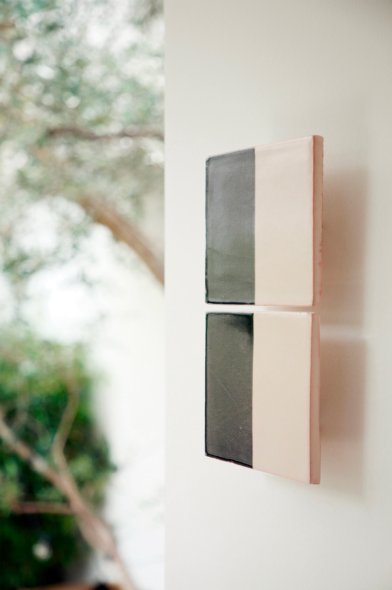 Les Tiles sont des appliques murales conçues par Violaine d'Harcourt en collaboration avec la designer hollandaise Marianne Smink. Utilisant le procédé de la sérigraphie, l'applique Tiles G est ainsi colorée d'un gris destroy et d'un beige représentant la céramique brute. L'ampoule, cachée derrière un carreau, diffuse un éclairage indirect, créant un effet de clair-obscur et un éclairage très doux.