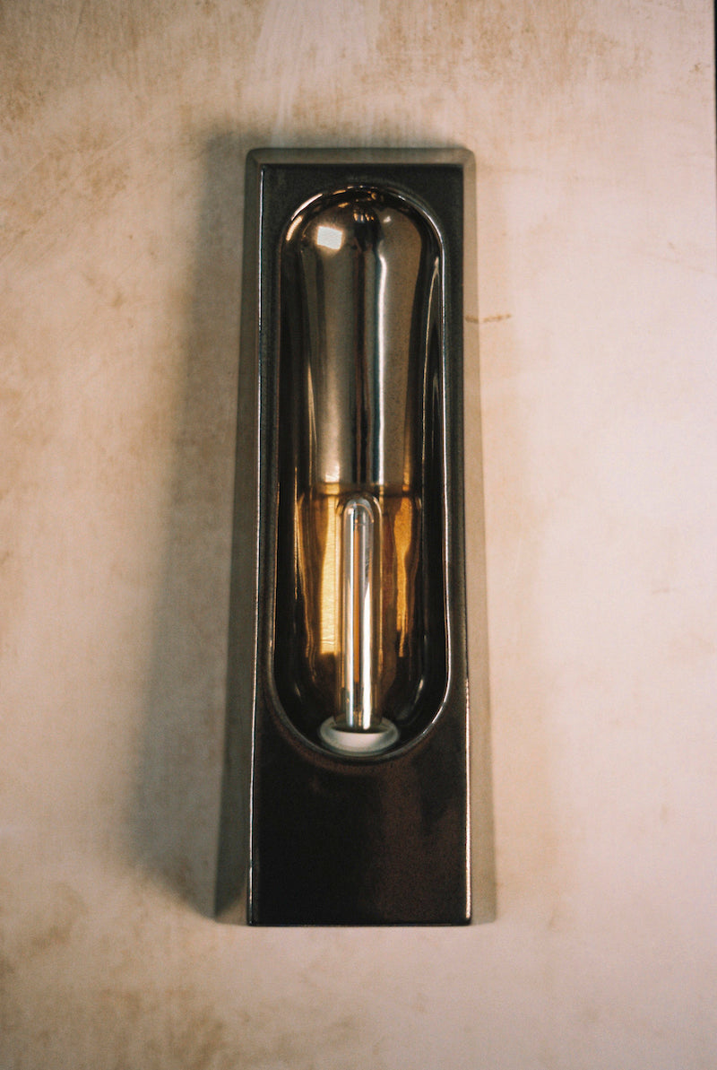 Alliance de l'artisanat et du design contemporain, les appliques Alcove de Violaine d'Harcourt sont fabriquées en céramique émaillée au Portugal, dans une région où le travail de l'argile est une tradition ancestrale. Leur forme s'inspire de l'élément architectural auquel elles ont emprunté leur nom - l'alcôve - qui évoque une ambiance intimiste et feutrée. Au centre de l'applique, une élégante ampoule tubulaire diffuse une lumière tamisée qui sublime les émaux aux teintes naturelles.&nbsp;