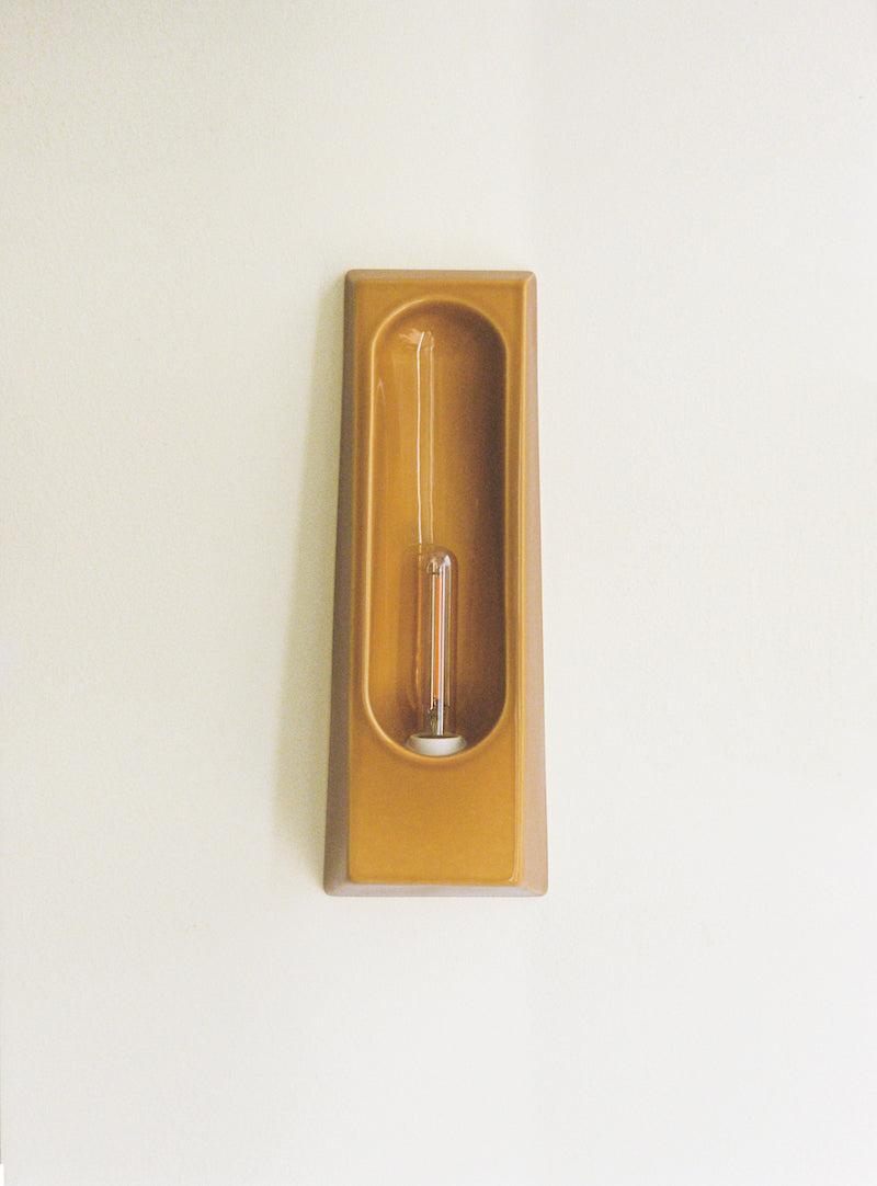 Wall sconce Alcove by Violaine d'Harcourt, in glazed ceramic hand-formed in Portugal. An enveloping silhouette inspired by the architectural alcove, diffusing softened, intimate light.