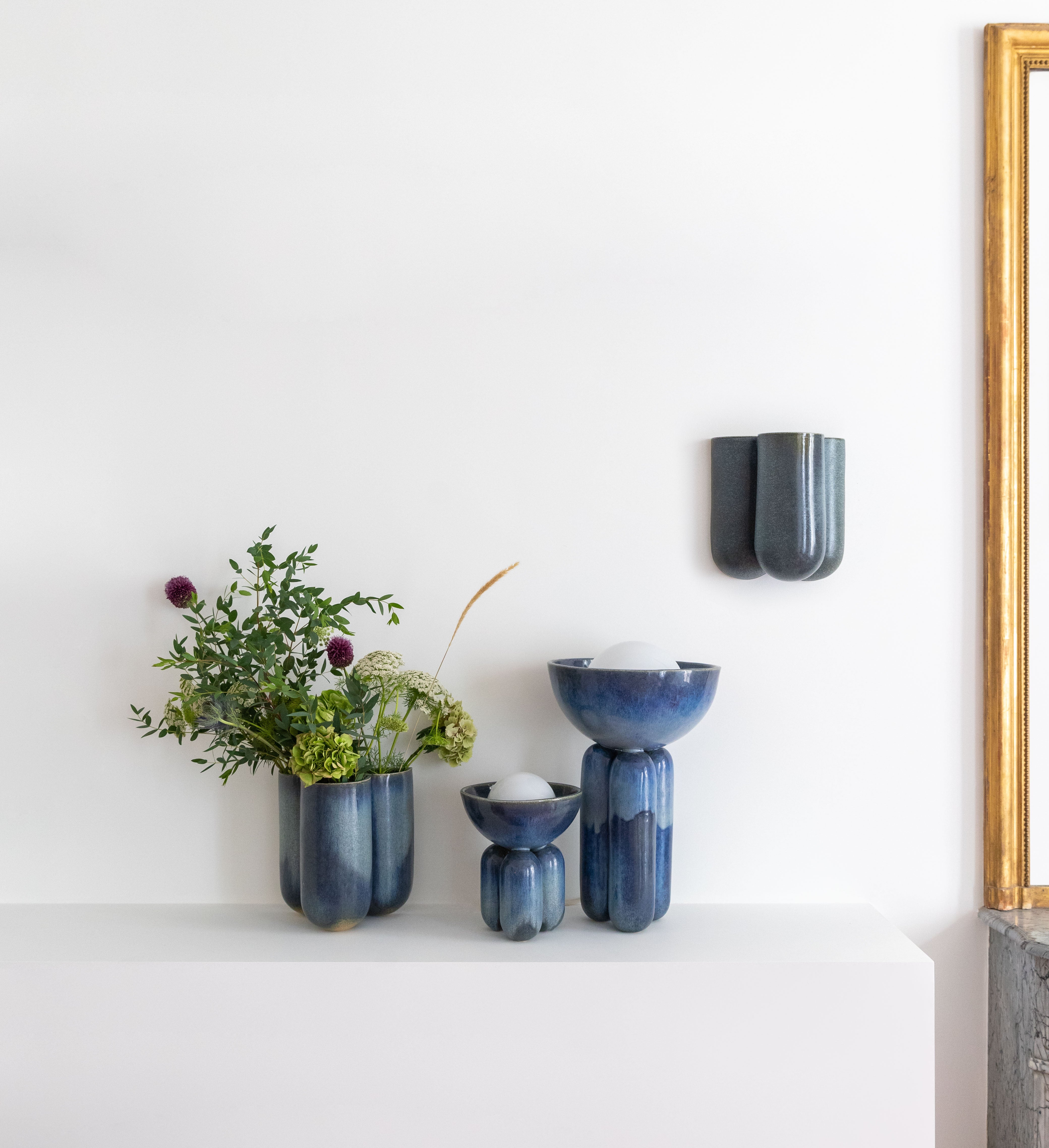 Lisa Allegra s'inspire de la forme arrondie d'une borne d'amarrage, la collection MOOR est aussi un clin d'œil à Henry MOORE, sculpteur de grands personnages se tenant souvent en équilibre dans l'espace.   Les pièces MOOR Lazuli allient un design pur et minimaliste à un émail aux nuances variées uniques. Cette association crée des objets à la fois fonctionnels et sculpturaux.