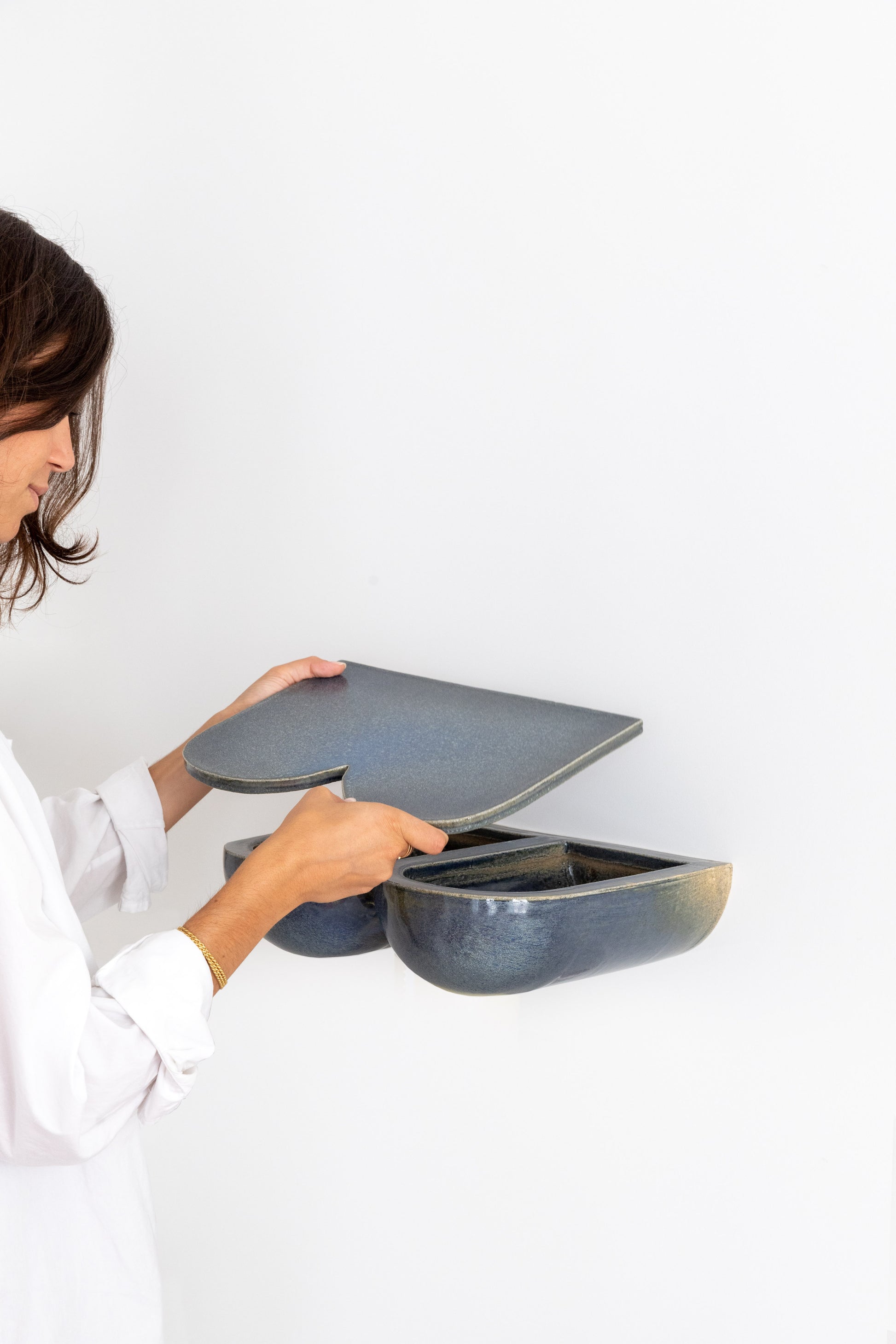 L'étagère, véritable pièce créative, aux lignes harmonieuses et généreuses saura habiller votre mur. En table de chevet ou dans votre entrée, en solo, duo ou trio... les combinaisons sont nombreuses et donnent libre cours à votre imagination. Ses rondeurs et son émail brillant couleur bleu lazuli lui donnent une allure douce et des airs de bijou artisanal. &nbsp;  Petite subtilité, une niche se cache sous la tablette amovible et fera office de rangement pour vos trésors, apportant une double.