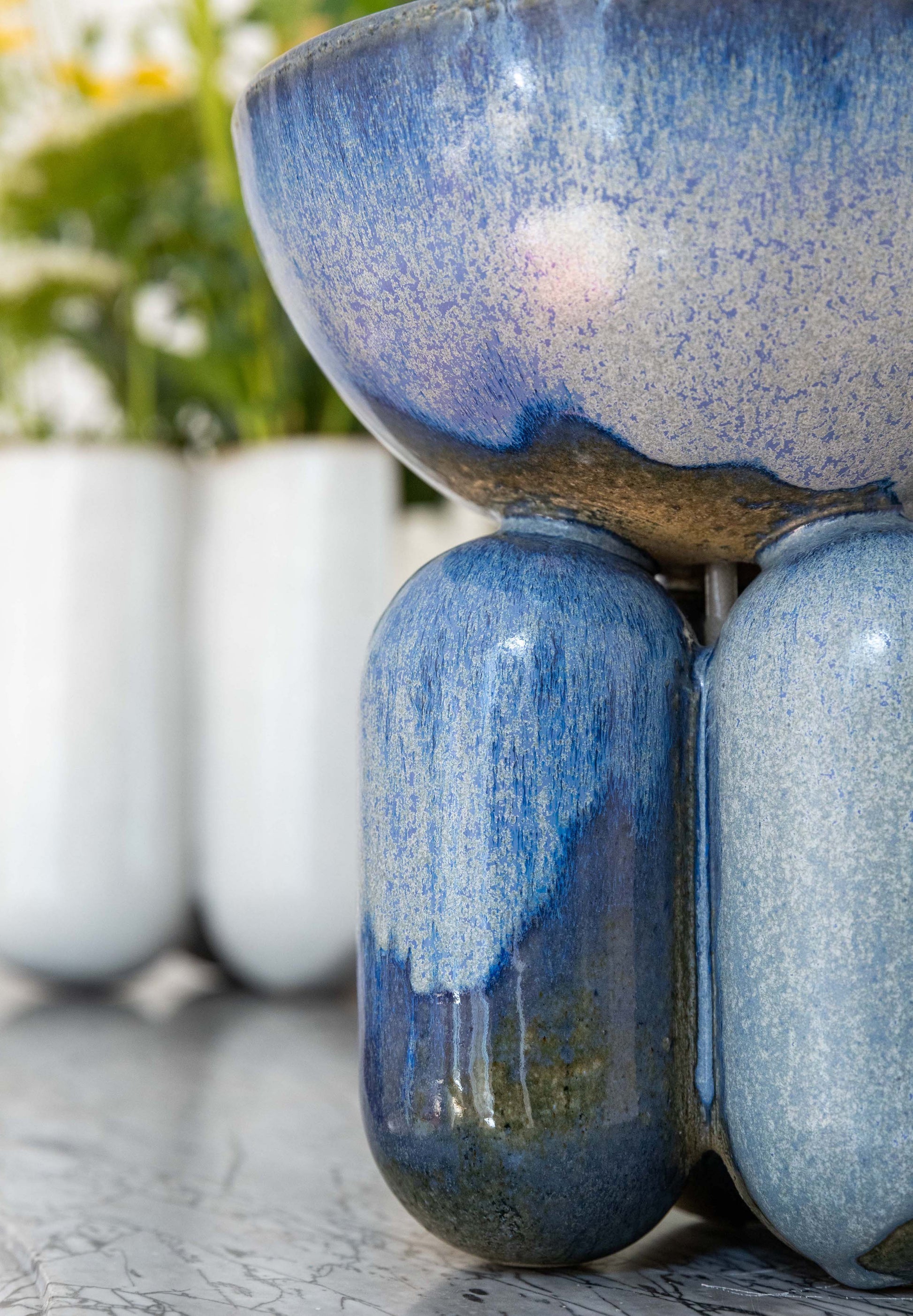 Lisa Allegra s'inspire de la forme arrondie d'une borne d'amarrage, la collection MOOR est aussi un clin d'œil à Henry MOORE, sculpteur de grands personnages se tenant souvent en équilibre dans l'espace.  Les pièces MOOR Lazuli allient un design pur et minimaliste à un émail aux nuances variées uniques. Cette association crée des objets à la fois fonctionnels et sculpturaux.