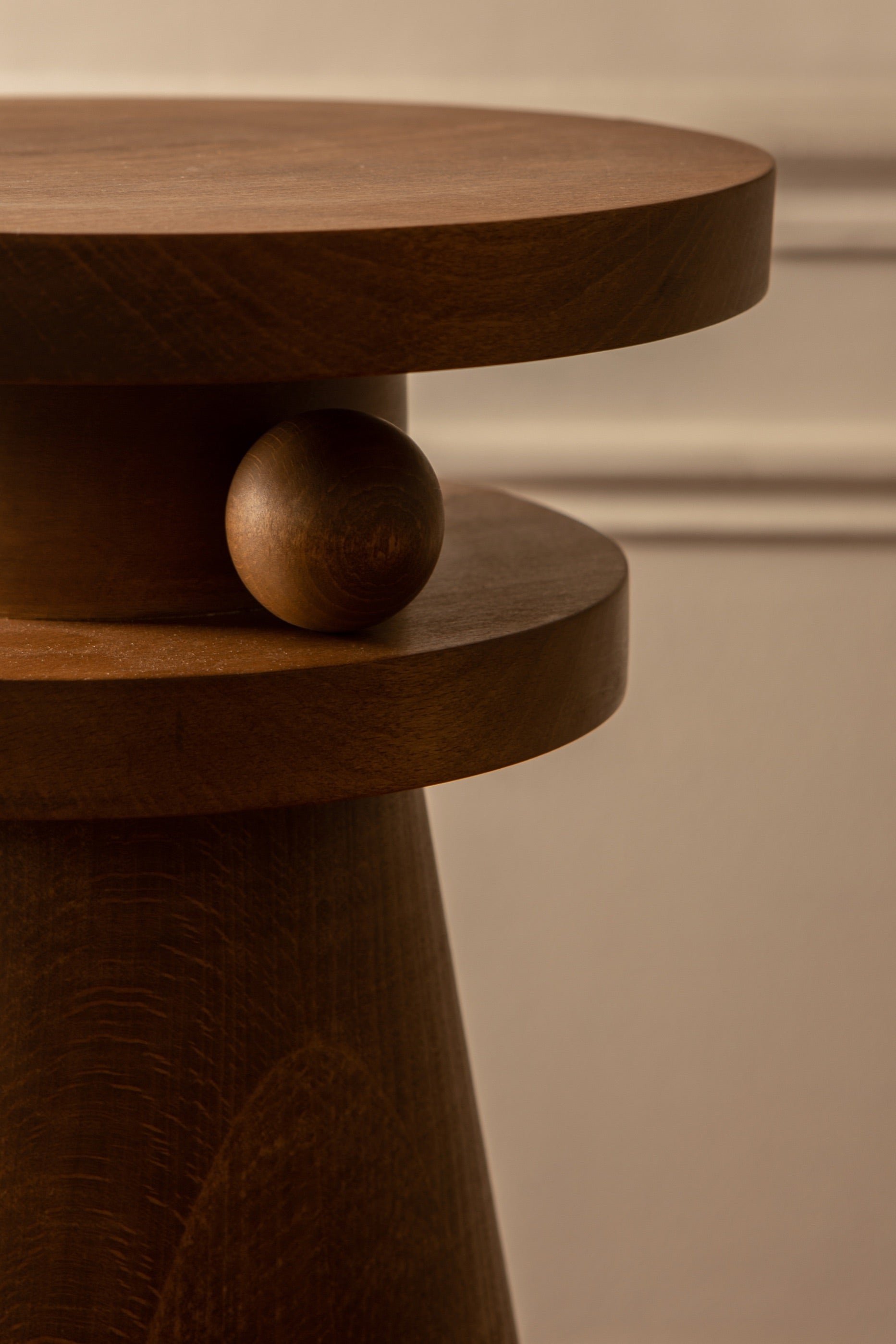 Joya est un objet de décoration nomade aux multiples usages. Tabouret, table d'appoint, bout de canapé, table de chevet, il a été conçu pour vous au quotidien selon vos envies et vos besoins suivre.   Il est décoré d'une boule sculptée entre ses deux plateaux, détail géométrique en asymétrie. Elle semble être posée délicatement, presque en mouvement : le gage d'un travail soigneux et minutieux.